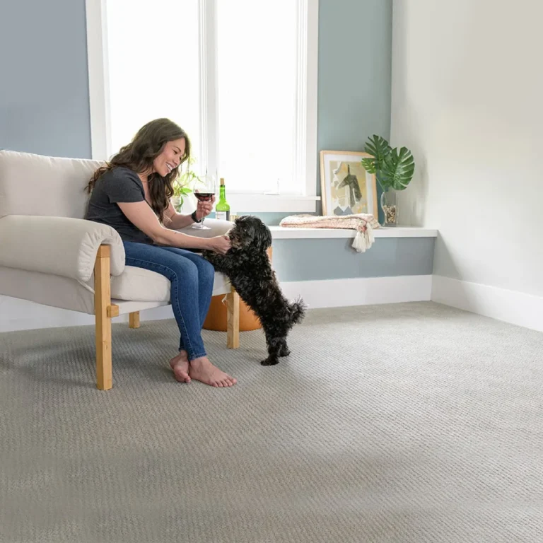 Woman sitting with her dog in a room with clean gray carpet
