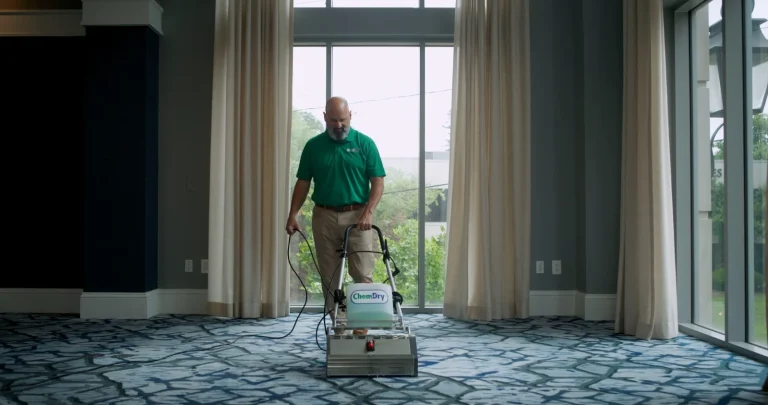 Chem-Dry technician cleaning patterned commercial carpet in an event room
